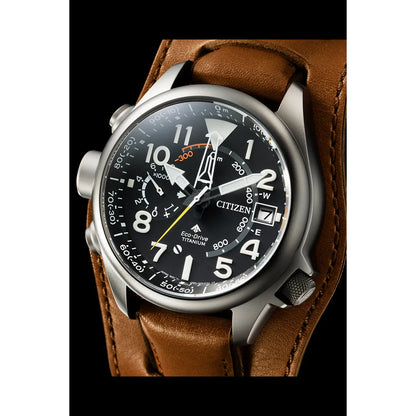 Detailní záběr na titanové pánské hodinky Citizen Eco-Drive s černým ciferníkem a hnědým koženým řemínkem