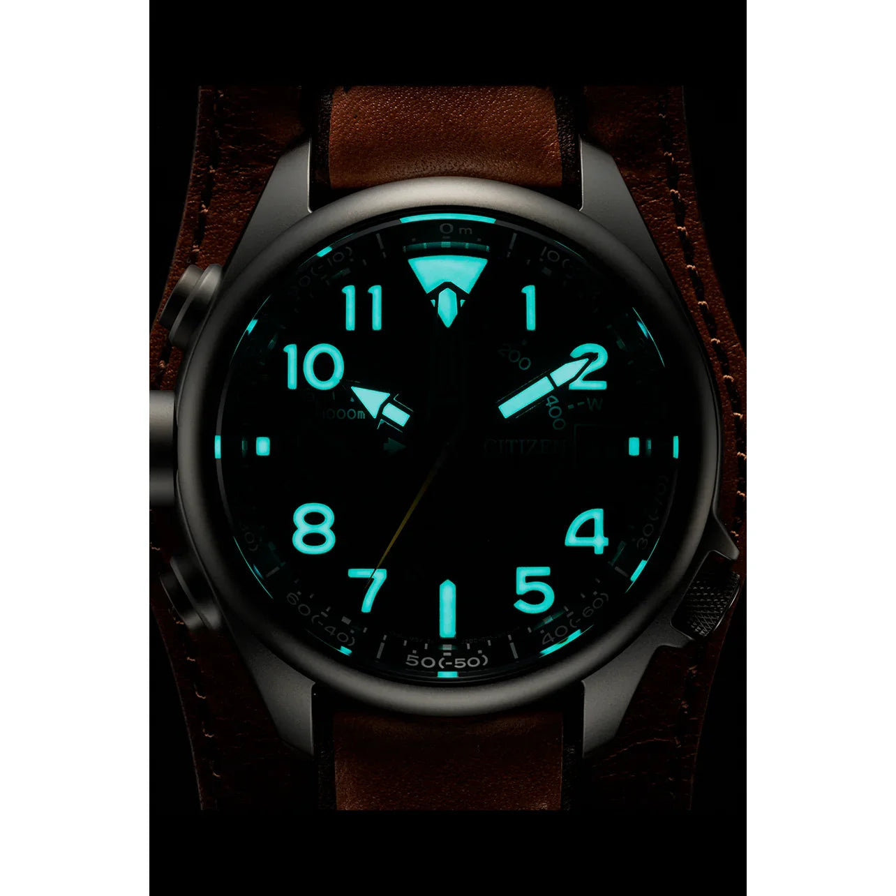 Svítící analogové náramkové hodinky se zářícími číslicemi a hnědým koženým řemínkem ve tmě