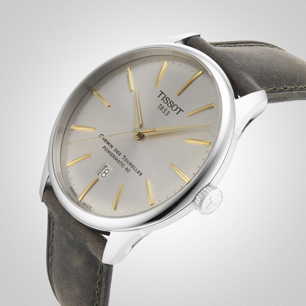 Elegant zilveren polshorloge met gouden uurmarkeringen, grijze leren band en datumweergave