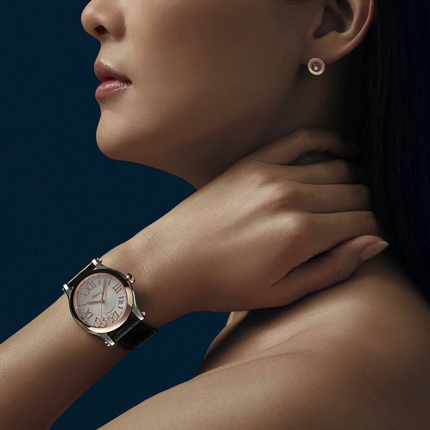 Elegant woman wearing luxury wristwatch with black leather strap and round dial
