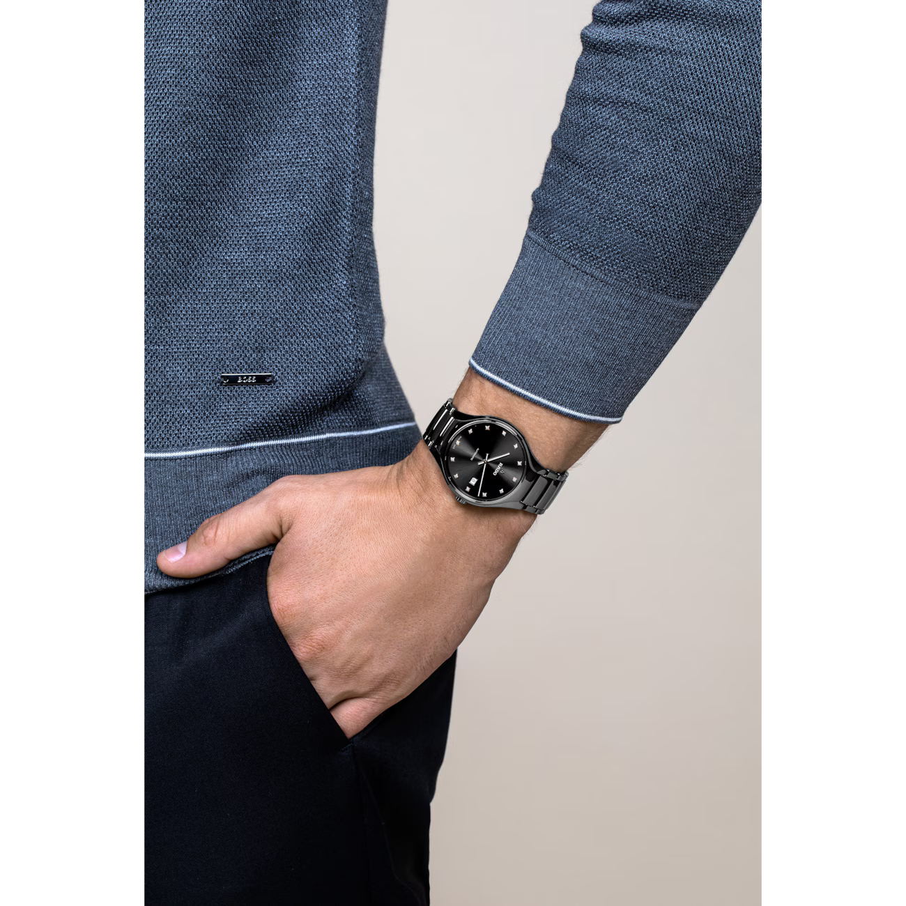 Luxe roestvrijstalen polshorloge met zwarte wijzerplaat om de herenpols met blauwe trui