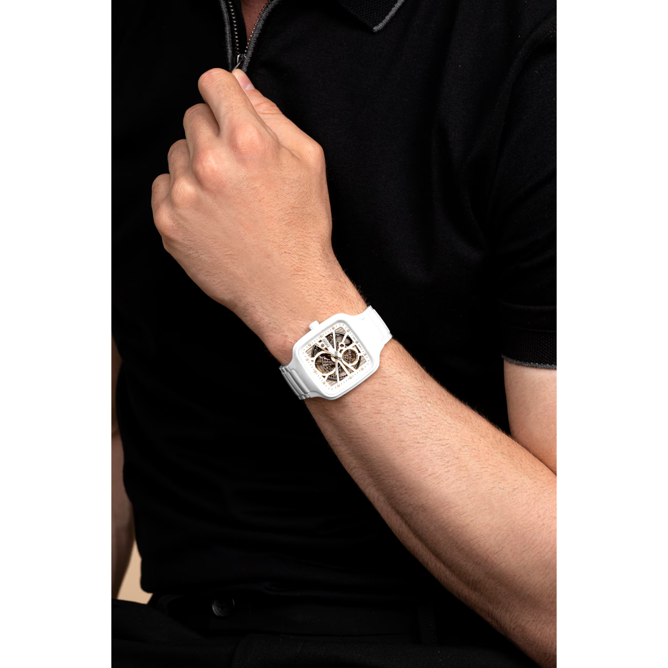 White square skeleton watch with openwork dial on wrist, modern luxury timepiece.