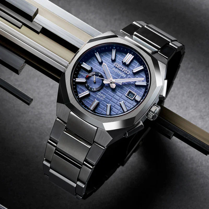 Titanium men's watch with blue patterned dial, GPS solar function, and date display